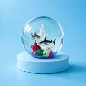 The kiedle ocean ball stress ball with sharks over a blue background